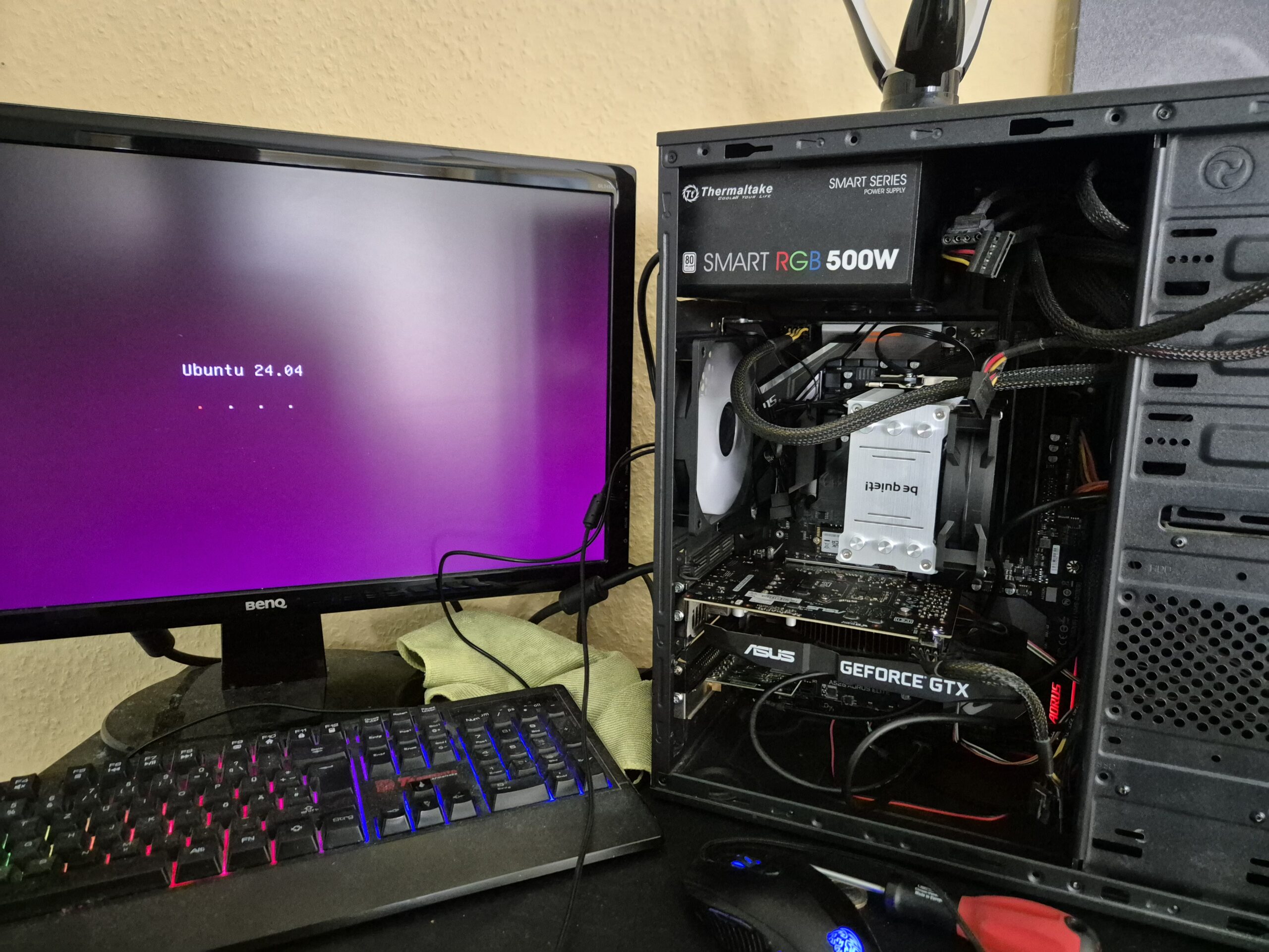 Offener PC mit wirrem Kabelsalat, Ubuntu-Installations-Screen auf dem Monitor daneben.